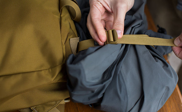 Using the lash straps to secure a rain shell to the bottom of the Paragon.